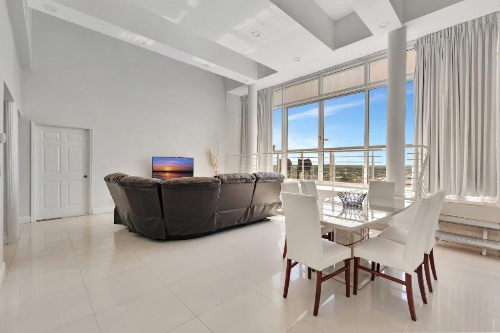 Penthouse 1104 living and dining area with floor‑to‑ceiling windows and Fort Lauderdale skyline view