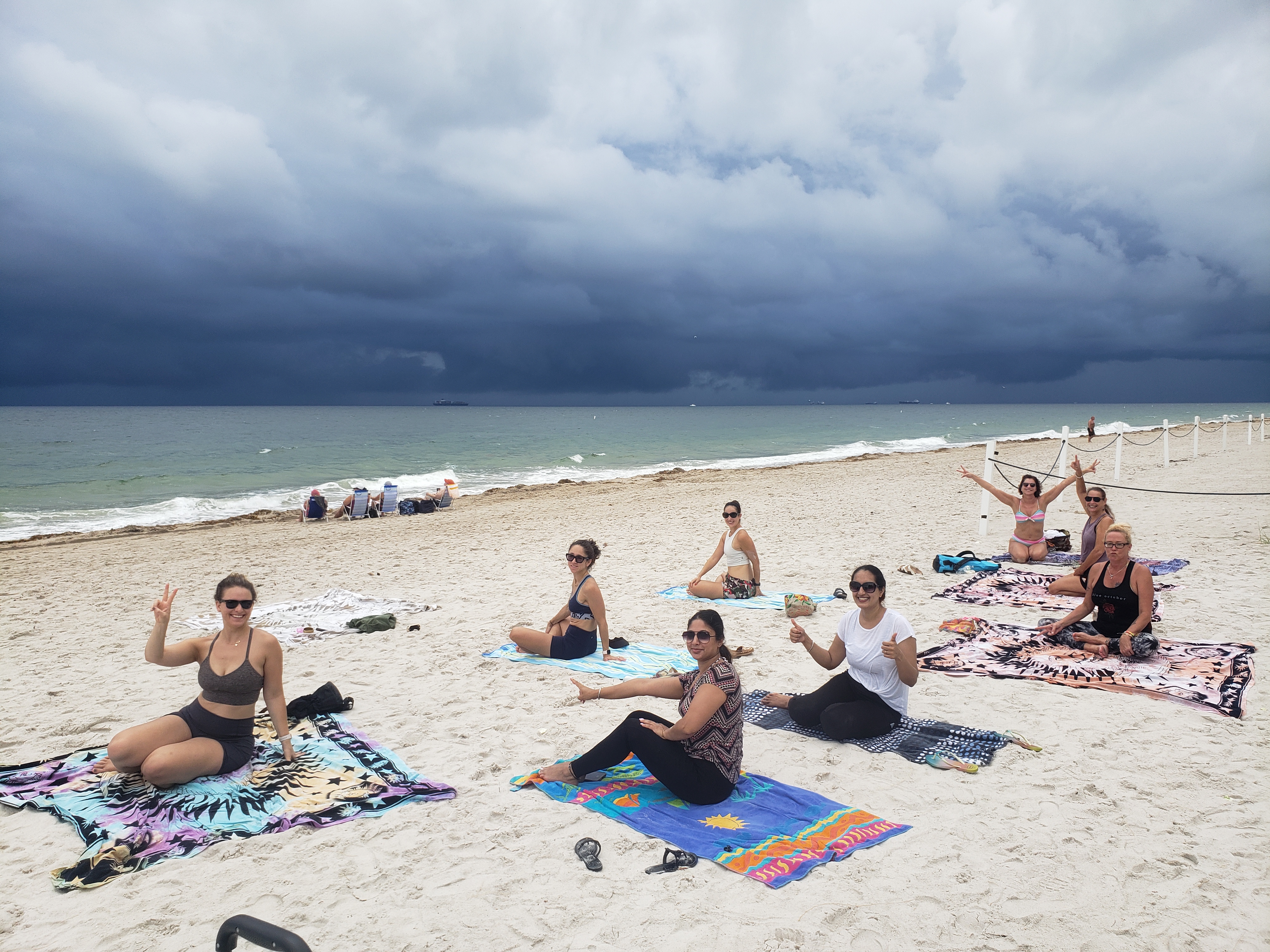 Happy yoga group class participants on the beach
